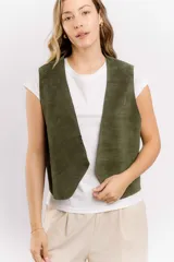 Chaleco de cuero gamuzado color verde militar, de corte recto y largo a la cintura.