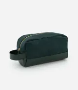 Neceser rectangular mediano de terciopelo verde oscuro con textura acanalada, cierre de cremallera dorada y asa lateral de cuero sintético.