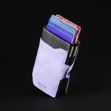 Billetera doble de cuero marrón con detalles en rosa. Cuenta con doble caja de aluminio con sistema de deslizamiento para tarjetas, clip para billetes y espacio adicional para documentos.