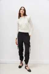 Pantalón jogger negro de nylon con elástico ancho en la cintura, puños elásticos ajustables y lazos laterales para fruncir.
