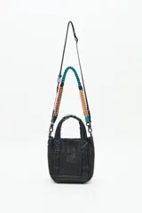 Cartera tote mini color negro, confeccionada en tejido tipo rafia. Cuenta con bolsillos internos, dos correas desmontables y abertura superior con cierre.