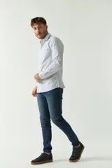 Camisa de hombre a rayas verticales celestes y blancas, corte slim fit, manga larga, logo bordado en el pecho y cartera con botones.