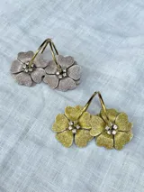 Aros de acero con forma de flor color azul con glitter y centro dorado con strass. Diseño 2en1 con doble flor de distinto color en cada lado.