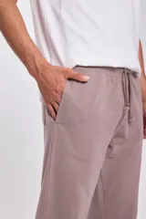 Pantalón deportivo color visón con cordón ajustable en la cintura y bolsillos laterales.