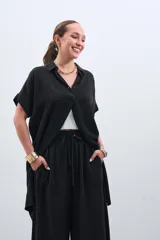 Camisola negra de tencel con cuello camisero, manga corta y cierre frontal con botones.