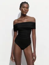 Body negro con escote bote drapeado y broches inferiores.