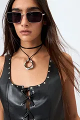 Top marrón de símil cuero con escote cuadrado, cordón cruzado en el frente y terminaciones con ojalillos metálicos.