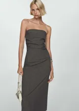 Vestido midi gris con finas rayas verticales blancas, de corte ajustado y sin mangas. Presenta escote strapless, detalle drapeado en la falda y abertura en la parte posterior.