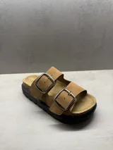 Sandalias marrones con dos tiras anchas y hebillas plateadas.