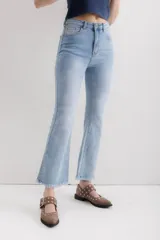 Pantalón jean marrón acampanado con detalle desflecado en el bajo y tiro medio.