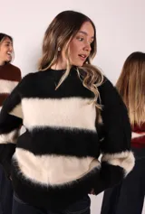 Sweater negro con franjas horizontales color crema, de corte oversized y tejido peludo.