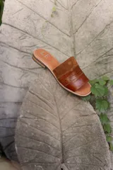 Sandalias de cuero negras con diseño de tiras cruzadas y detalle de elástico en el talón.