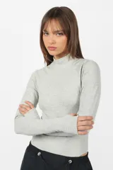 Body manga larga color beige, de punto roma, con cuello alto y mitones en los puños.