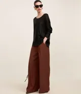 Blusa negra de punto liviano con escote redondo, manga larga y sisa raglán. Tiene una malla con lámina metálica.