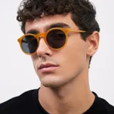 Lentes de sol redondos con montura de policarbonato color amarillo y lentes polarizados negros.