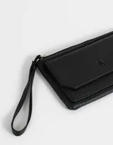 Billetera tipo sobre color negro de cuerina con cierre superior y bolsillo frontal con broche y botón.