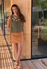 Top color beige de cuero con flecos en los laterales y caracoles buzios en el frente. Espalda tejida.