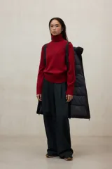 Campera acolchada larga, color blanco, con capucha grande y cierre frontal de cremallera negra. Presenta bolsillos laterales con cremallera negra.