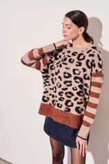 Sweater oversize con estampado animal print en tonos beige y negro, con mangas rayadas en color marrón.