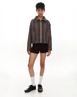 Chaqueta corta de gabardina de algodón con estampado a rayas en tonos marrón y gris. Tiene cuello alto, cierre metálico frontal, bolsillos de parche y forro interior.