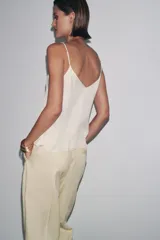 Top color crema de Zara Woman Collection, con escote pico, tirantes finos ajustables y detalle de encaje a tono.