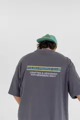 Remera gris con estampa en la espalda que dice 'Pulau People Club Crafted & Designed for members only'.