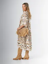 Vestido midi de algodón italiano, color blanco con estampado boho chic en tonos naranja, marrón y verde. Tiene corte oversized, mangas 3/4 con volados y cinturón de soga trenzada con hebilla circular.