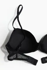 Soutien push-up negro de malla con diseño de lunares. Modelo de media copa y corte bajo con breteles ajustables, copas acolchadas con aros y cierre de corchetes en la espalda.