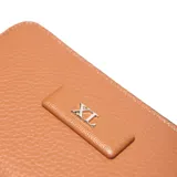 Billetera de mujer color caramelo, con textura de cuero granulado y cierre de cremallera perimetral. Presenta un aplique rectangular con el logo "XL" en el frente.
