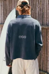 Buzo de tejido de punto gris oscuro con textura acanalada vertical y cuello polo con escote en V. Presenta un estampado grande en blanco con el texto "glassy wa".