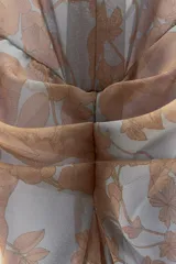 Vestido largo de gasa color celeste con estampado floral color dorado, escote fluido, mangas cortas con abertura, detalle de frunce en el delantero y espalda con escote pronunciado. Incluye forro interior de tirantes al tono.