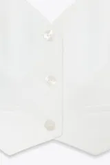 Chaleco blanco con cuello halter ajustable, escote pico, falsos bolsillos de vivo en delantero, detalle de costuras marcadas, forro interior a tono y cierre frontal con botones.