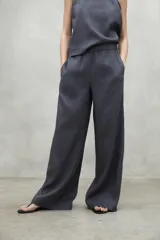 Pantalón de lino gris, de pierna ancha y ajuste holgado, con cintura elástica y bolsillos laterales.