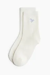 Pack de siete pares de medias de algodón en punto fino, con diseños lisos y estampados florales en tonos pastel.