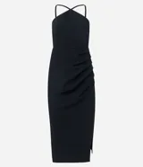 Vestido midi negro de bengalina, sin mangas, con breteles finos, escote halter, pliegues, abertura lateral y cierre por cremallera en la espalda.