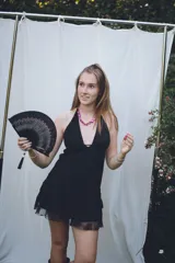 Vestido corto con lentejuelas color verde esmeralda, escote en V profundo y espalda descubierta.