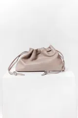 Bolso tipo sobre de cuero color rojo, con frunce superior y cierre con cordones. Tiene correa larga desmontable y bolsillo interno con cierre.