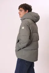 Campera puffer gris con capucha, cierre frontal con cremallera y bolsillos laterales con cierre.