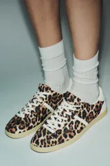Zapatillas deportivas con estampado animal, cordones blancos y suela color caramelo.