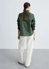 Camisa verde militar de lino y algodón, con cuello camisero, cierre frontal con botones, manga larga con puños abotonados y bolsillo de parche en el pecho.