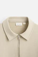 Sudadera negra de algodón con cuello polo y cierre de cremallera.