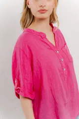 Camisa azul de lino con escote en V abotonado, bolsillo frontal y mangas 3/4 con trabilla.