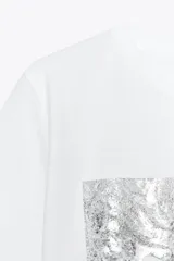 Camiseta blanca de corte recto y manga corta, con estampado frontal de una fotografía en blanco y negro y texto "Amsterdam 74".