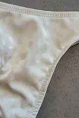 Conjunto de bikini verde esmeralda, con corpiño triangular de atar al cuello y espalda, con almohadillas desmontables, y bombacha colaless con laterales fijos.