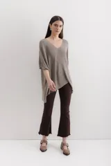 Sweater tejido de punto color crudo, con escote en V, mangas 3/4 y corte holgado.