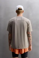 Camiseta deportiva color beige confeccionada en tejido con estructura, ligero y elástico en todas direcciones. Tiene cuello redondo, manga corta, costuras planas y logo estampado en el bajo.