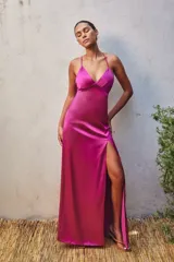 Vestido largo fucsia de satén con breteles finos, escote en V y abertura lateral en la pierna.