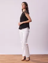 Blusa negra de crepe con apliques de crochet en los hombros. Tiene cuello redondo, mangas cortas y espalda con abertura ojal y botones.