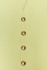Chaleco color verde claro de punto con escote pico y cierre frontal con botones dorados.