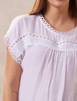 Blusa blanca de gasa marca Palm Rio, con cuello a la base y manga corta japonesa. Aplique de crochet en cuello, ruedo de manga y delantera.